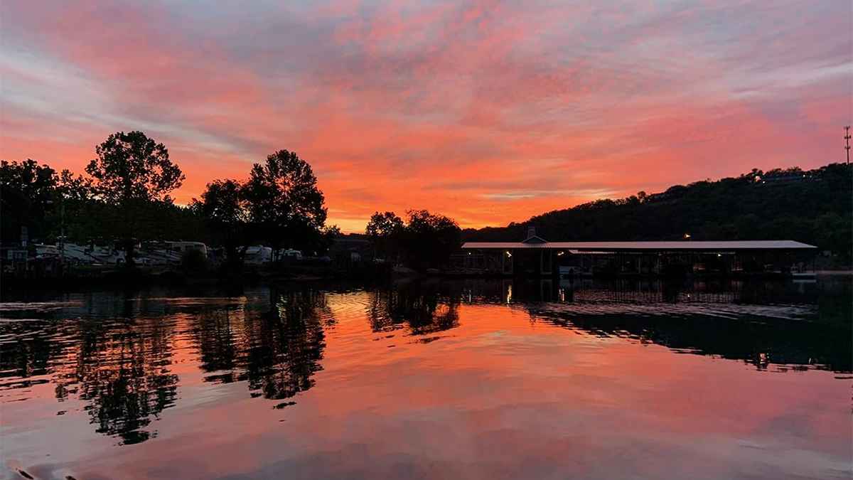 Lake Taneycomo with a bright pink sunset reflecting on the water in Branson, Missouri, USA