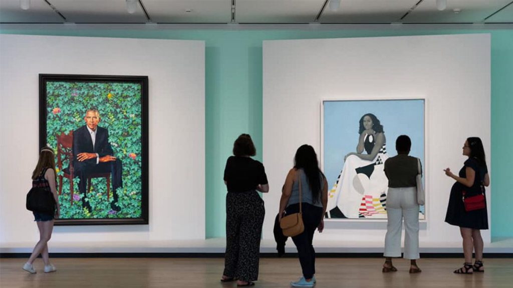 Wide shot of a group of women looking at the portraits of the Obama's at the Art Institute of Chicago in Chicago, Illinois