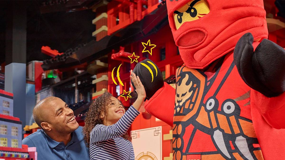 Child and her dad high-fiving a LEGO Ninja at the Legoland Discovery Center in Chicago, Illinois