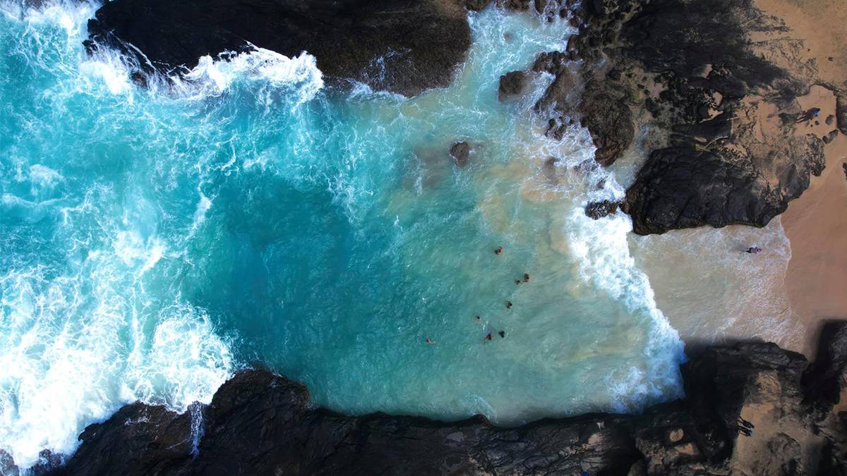Aerial view of the beach at Halona Blowhole in the day time with crisp blue water in Oahu, Hawaii