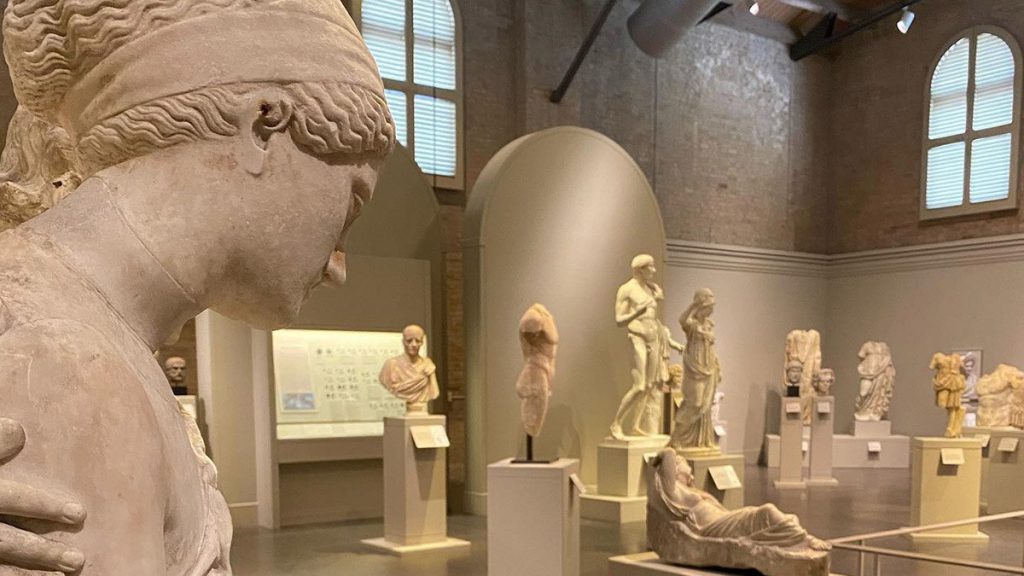 Close up of female statue with several statues in the background, all of them are shades of beige at the San Antonio Museum of Art in San Antonio, Texas