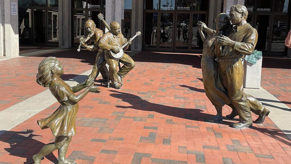 Close up photo of bronze statues dancing and playing music on the Urban Trail in Asheville, North Carolina, USA