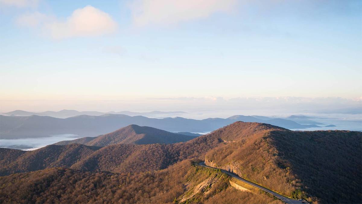 Photo over looking Craggy Gardens with a road running through it with a blue cloudy sky in Asheville, North Carolina, USA