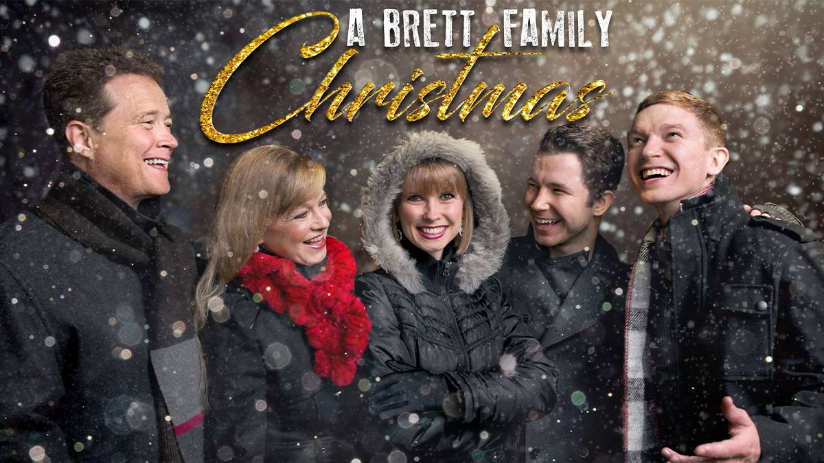 A Brett Family Christmas photos of three men and two women in coats with snow falling around them in Branson, Missouri, USA