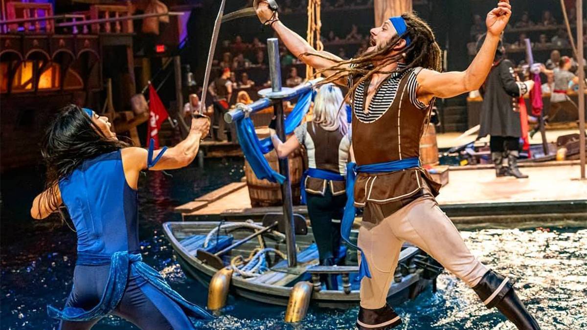 Two pirates sword fighting with a ship and water in the background at the Pirates Voyage Dinner and Show in Myrtle Beach, South Carolina, USA