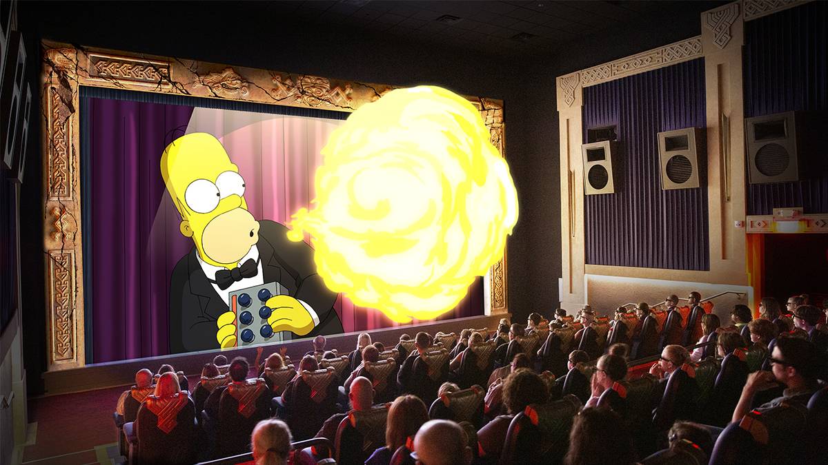 Aztec Theatre full of people with Homer breathing fire on the screen and the fire looks like it is going over the audience in Myrtle Beach, South Carolina