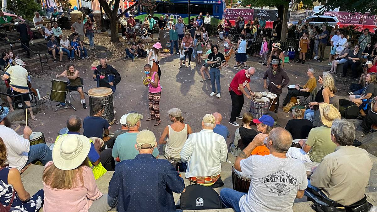 Wide shot of the Friday Night Drum Circle with lots of people attending in Asheville, North Carolina , USA