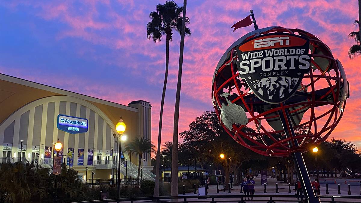 Close up photo of the ESPN Wide World of Sports complex globe with the arena and a bright purple and pink sunset in the background in Orlando, Florida, USA