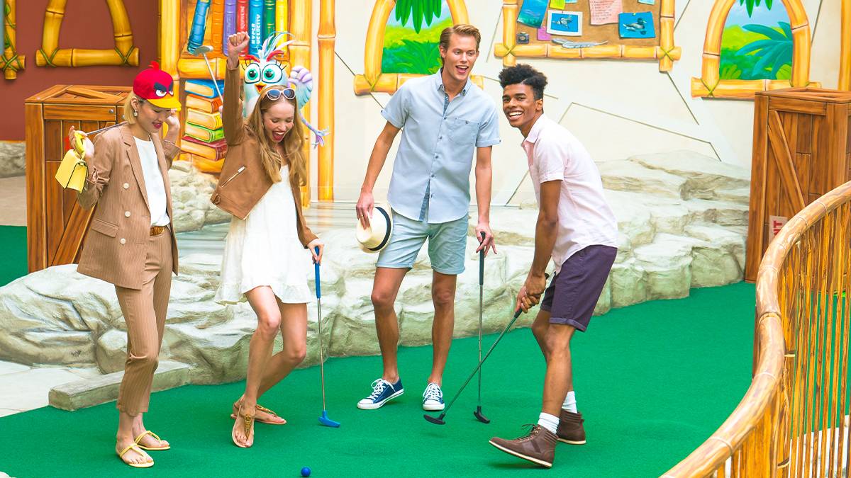 Group of friends, two men two women, playing mini golf at Angry Birds Mini Golf in the American Dream Mall in Rutherford, New Jersey, USA