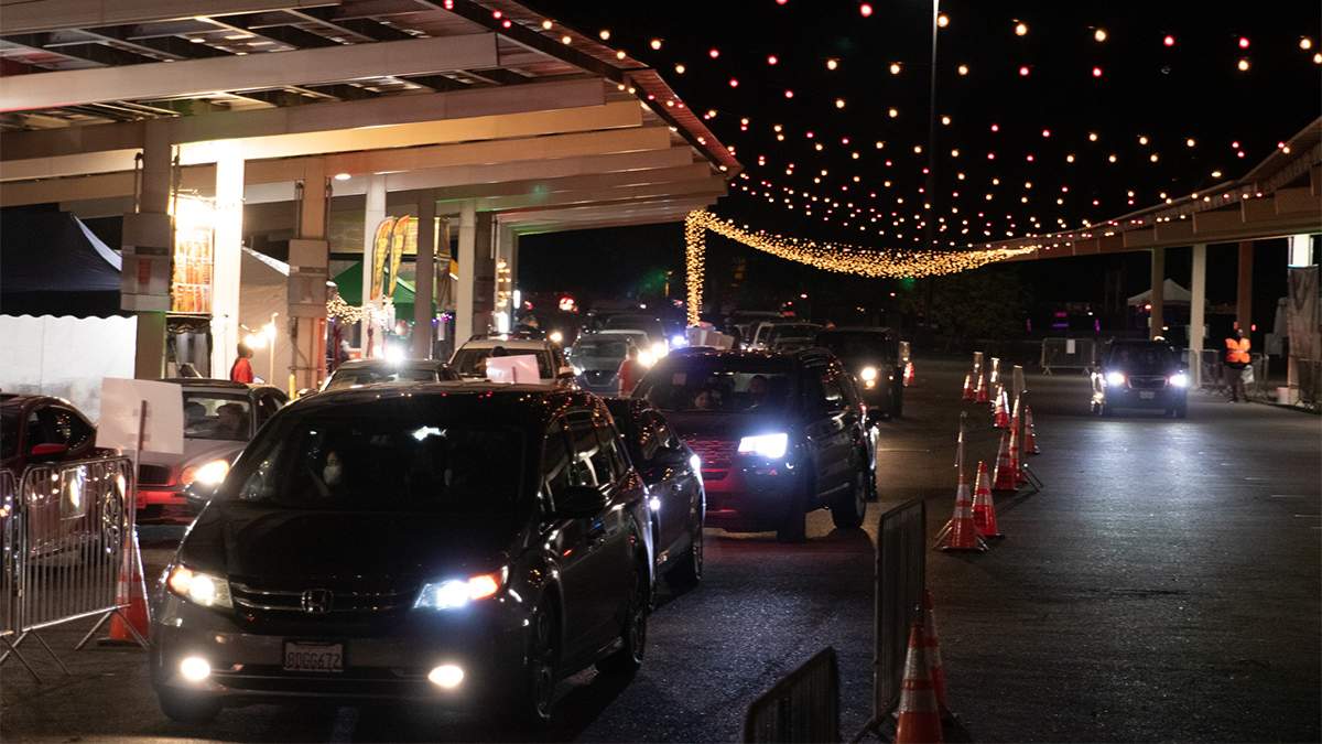 Cars lining up with strings of lights over head at Taste of December Nights in San Diego, California, USA