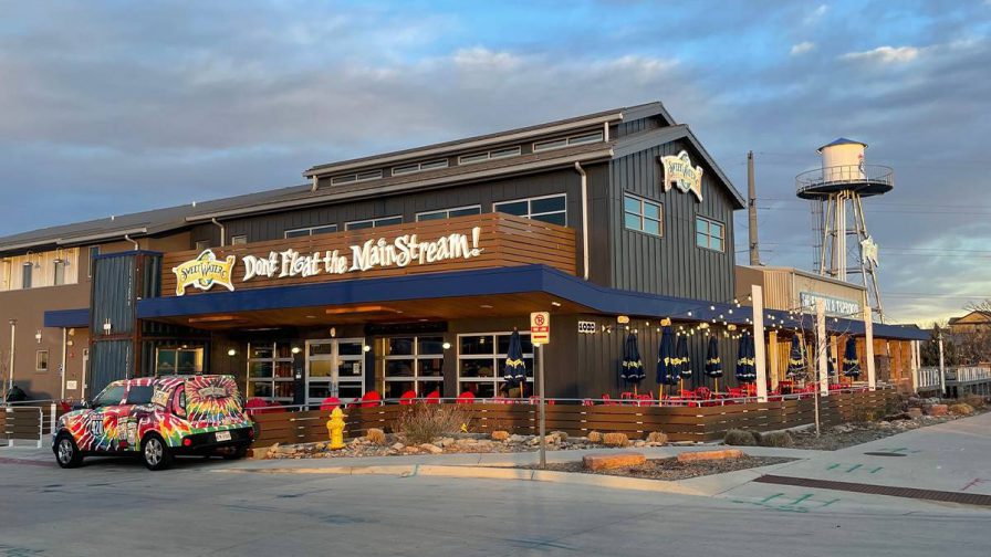Wide shot of the SweetWater Brewery Company at sunset with red chairs and blue umbrella in the outside dining area in Atlanta, Georgia, USA