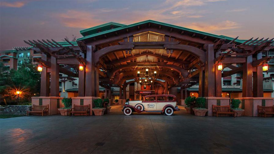 The entrance to Disney's Grand Californian Hotel & Spa, large wooden structure with a green roof, with a vintage car parked in the center in Los Angeles, California, USA