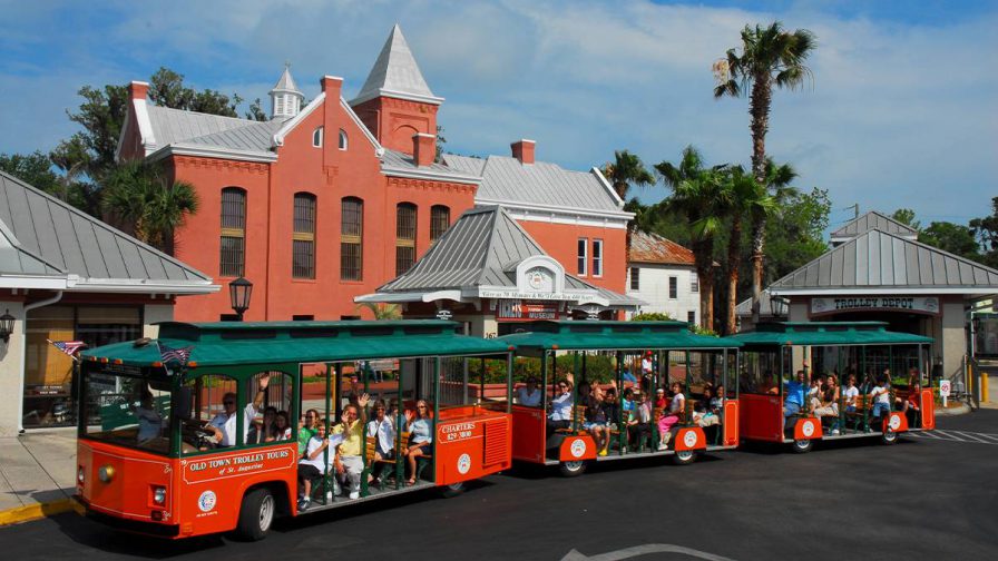 Wide shot from above of the Old Town Trolley full of people ready for a tour on a sunny day in St Augustine, Florida, USA