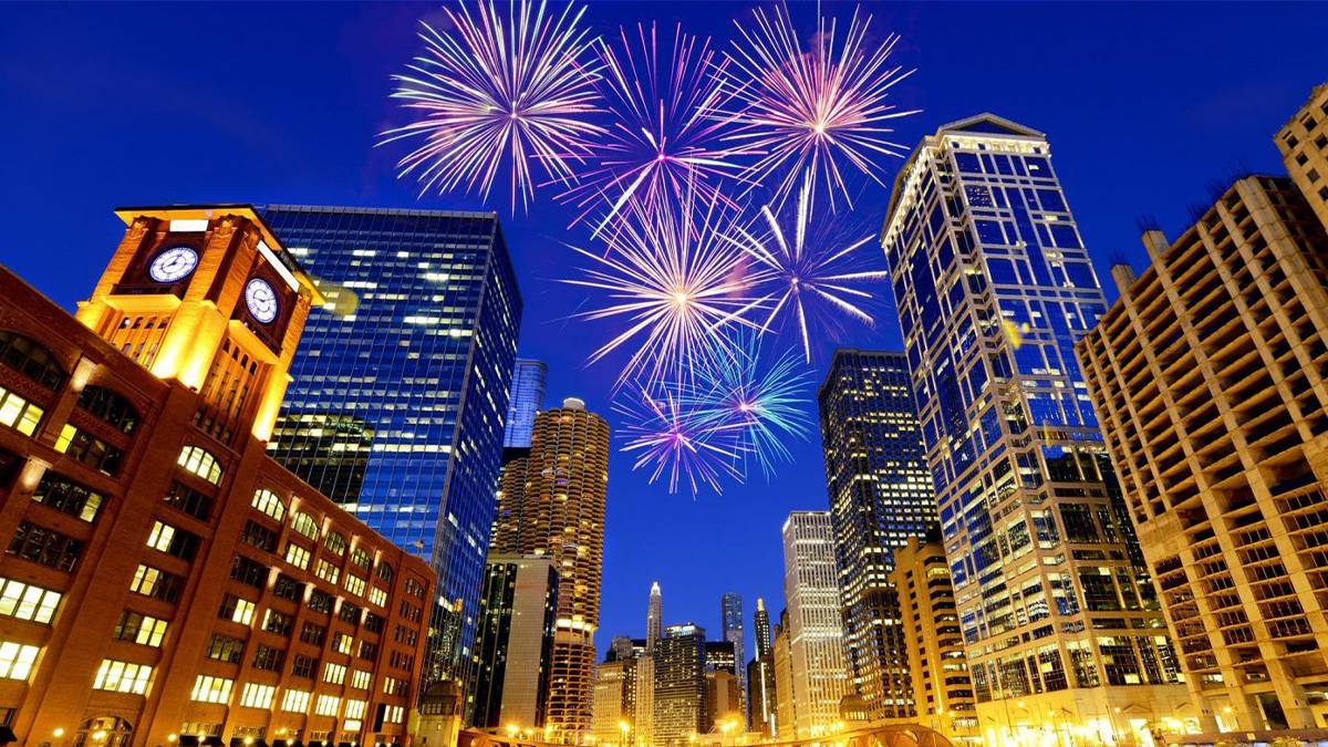 red fireworks at night over Chicago River and city downtown skyline in Chicago, Illinois, USA