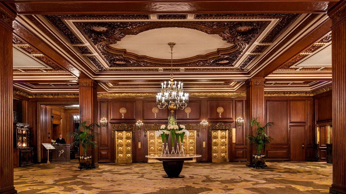 lobby of Omni Parker House with ornate ceiling and walls, chandelier, and table in middle of room with flowers in Boston, Massachusettes, USA