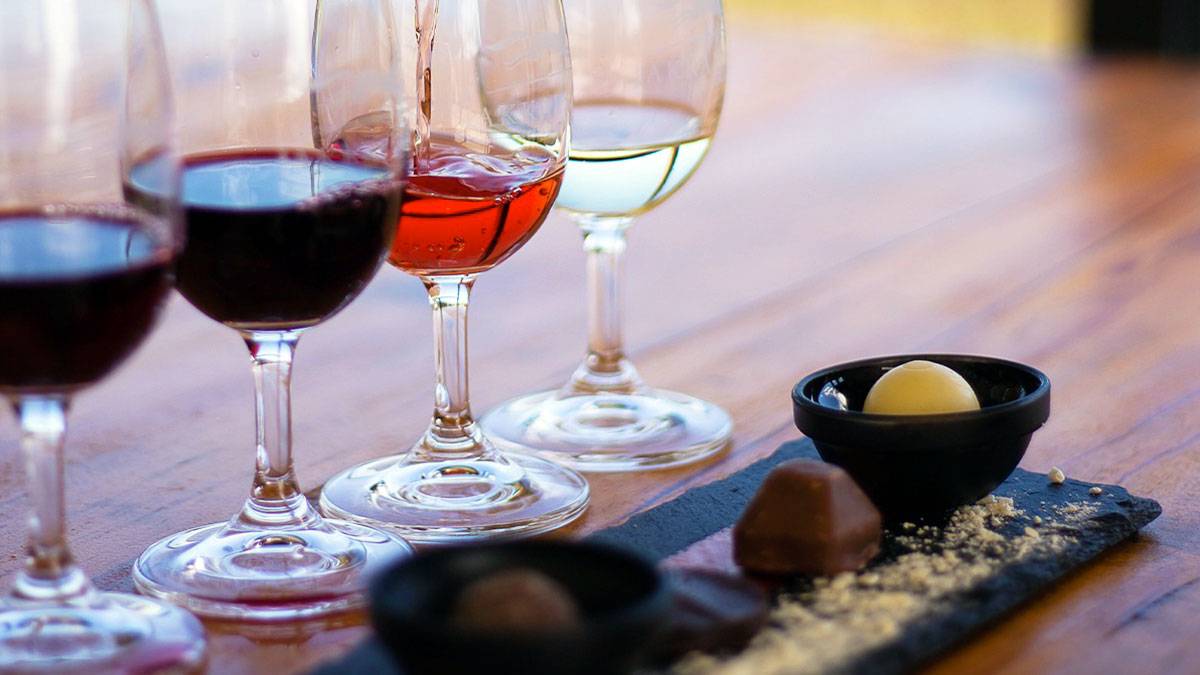 glasses with different selections of wine next to different types of chocolate candies