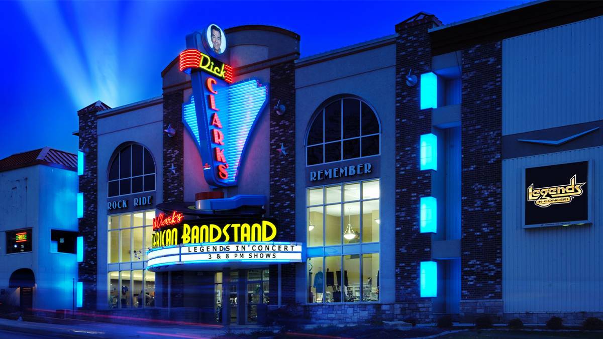 Wide shot of the outside of Dick Clark's American Bandstand Theater - Legends in Concert at night with skylights on in Branson, Missouri, USA