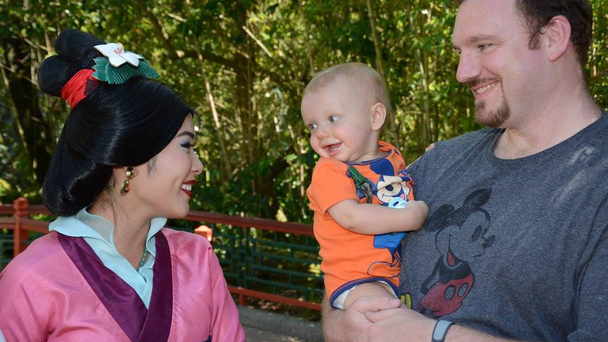 Father with a baby meeting Mulan at Walt Disney World in Orlando, Florida, USA