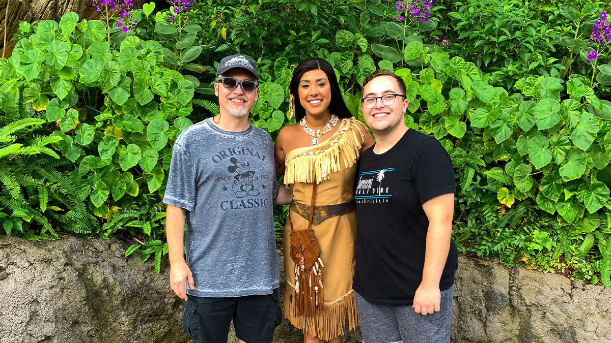 Two men posing with Pocahontas for a photo at Walt Disney World in Orlando, Florida, USA