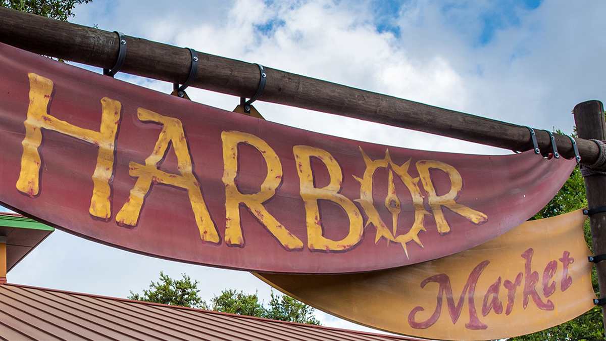 Close up of the sign for the Harbor Market, red and yellow banners hanging from wooden beams at SeaWorld in San Antonio, Texas, USA