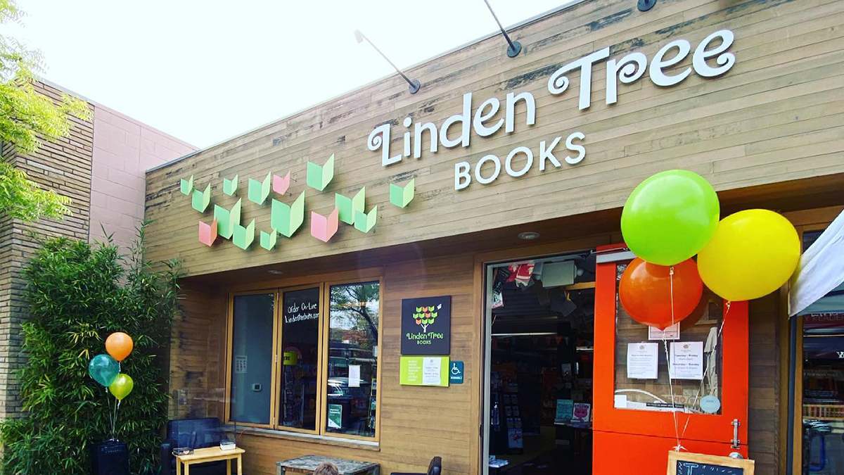 View of the front of Linden Tree Books Los Altos, wooden siding with a large white sign and book butterflies on a sunny day in San Francisco, California, USA