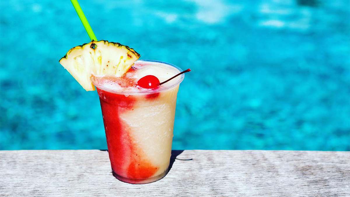 Close up of the Miami Vice drink with the blue pool water in the background at Postcard Inn St. Pete Beach near Tampa, Florida, USA